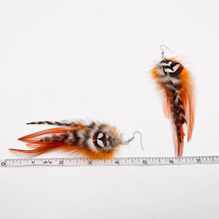 Oranssinsävyiset sulkakorvakorut