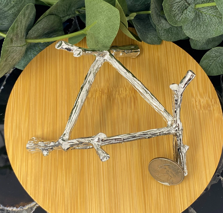 A large silver-plated metal stand for a crystal ball