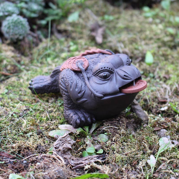 Rupikonnateefiguuri sammakko ja keraaminen kolikko